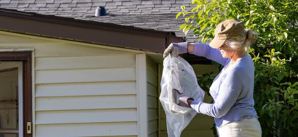 A woman cleaning her gutters